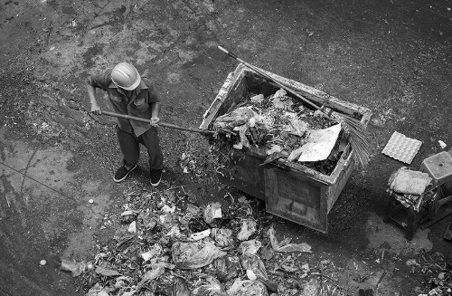 Skip hire truck with staff at a depot